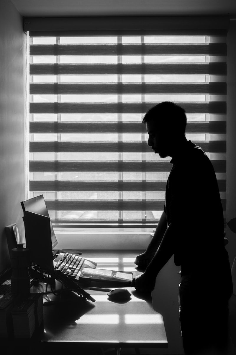 A man standing in front of a computer in a room